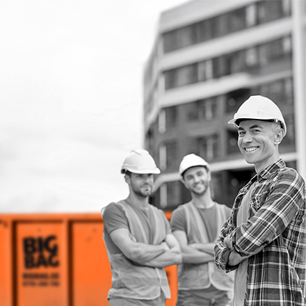 Tre byggjobbare framför BIG BAG-container