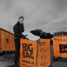 man lastar en BIG BAG, contanier och kärl i bakgrunden